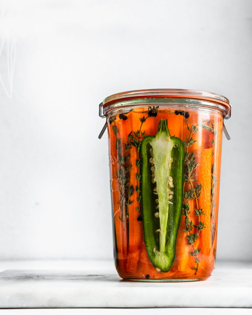 lacto-fermented carrots with half of a jalapeno pepper